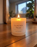 Glacier Peak 8 oz Ritual Refill candle with glowing wooden wick on a wooden table