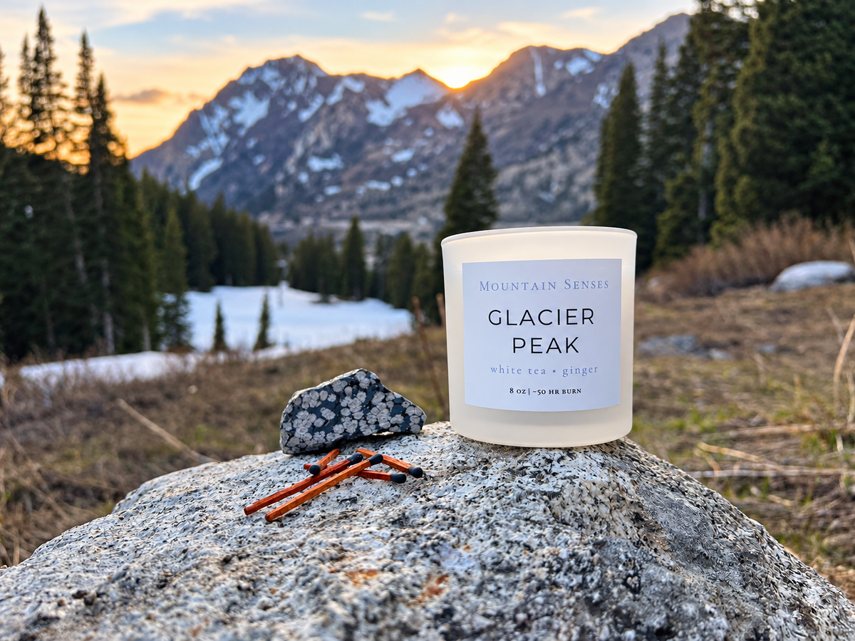 Glacier Peak winter candle with snowflake obsidian and wooden matches in a mountain setting