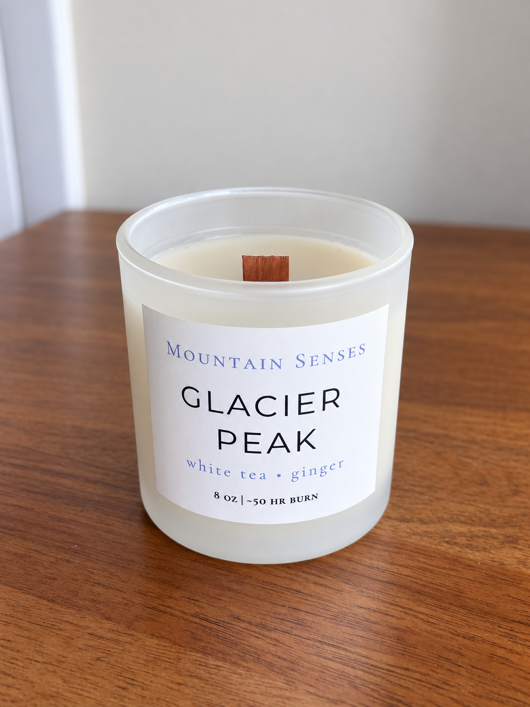 Glacier Peak 8 oz Ritual Refill candle with unlit wooden wick on a wooden table