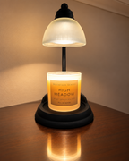High Meadow Ritual Refill candle under a glowing candle warmer lamp; warmer not included