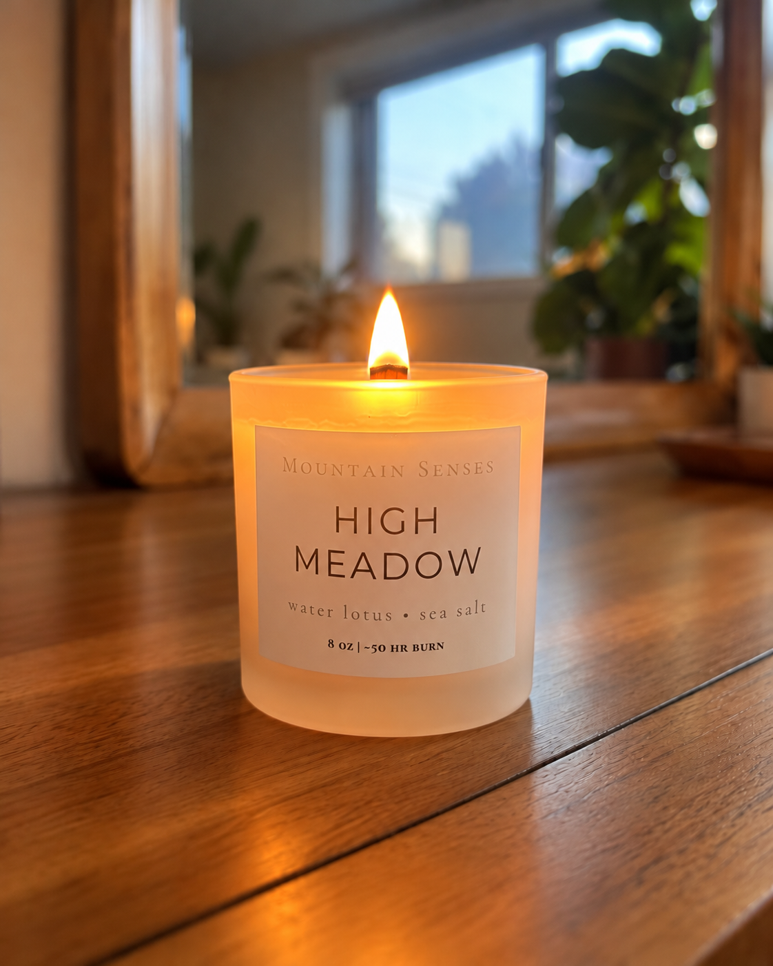 High Meadow 8 oz Ritual Refill candle with glowing wooden wick on a wooden table