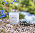 High Meadow spring candle with green natural stone and blue flowers near a stream