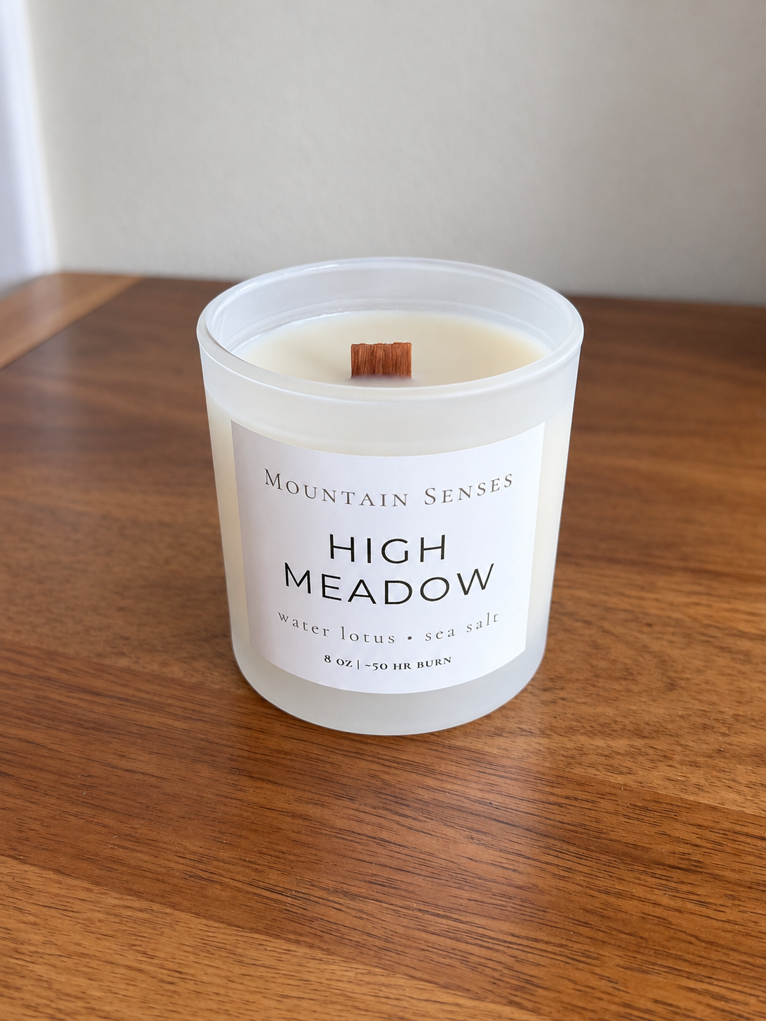 High Meadow 8 oz Ritual Refill candle with unlit wooden wick on a wooden table