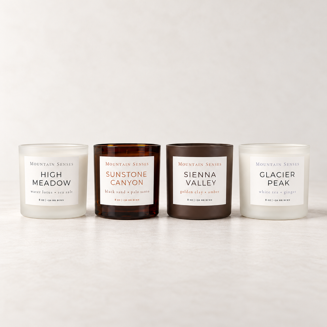 Four Seasons Candle Collection featuring High Meadow, Sunstone Canyon, Sienna Valley and Glacier Peak candles together on a cream studio background