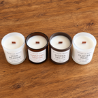 Four Seasons candle collection from above showing all four fragrances and their wooden wicks on a warm wooden table