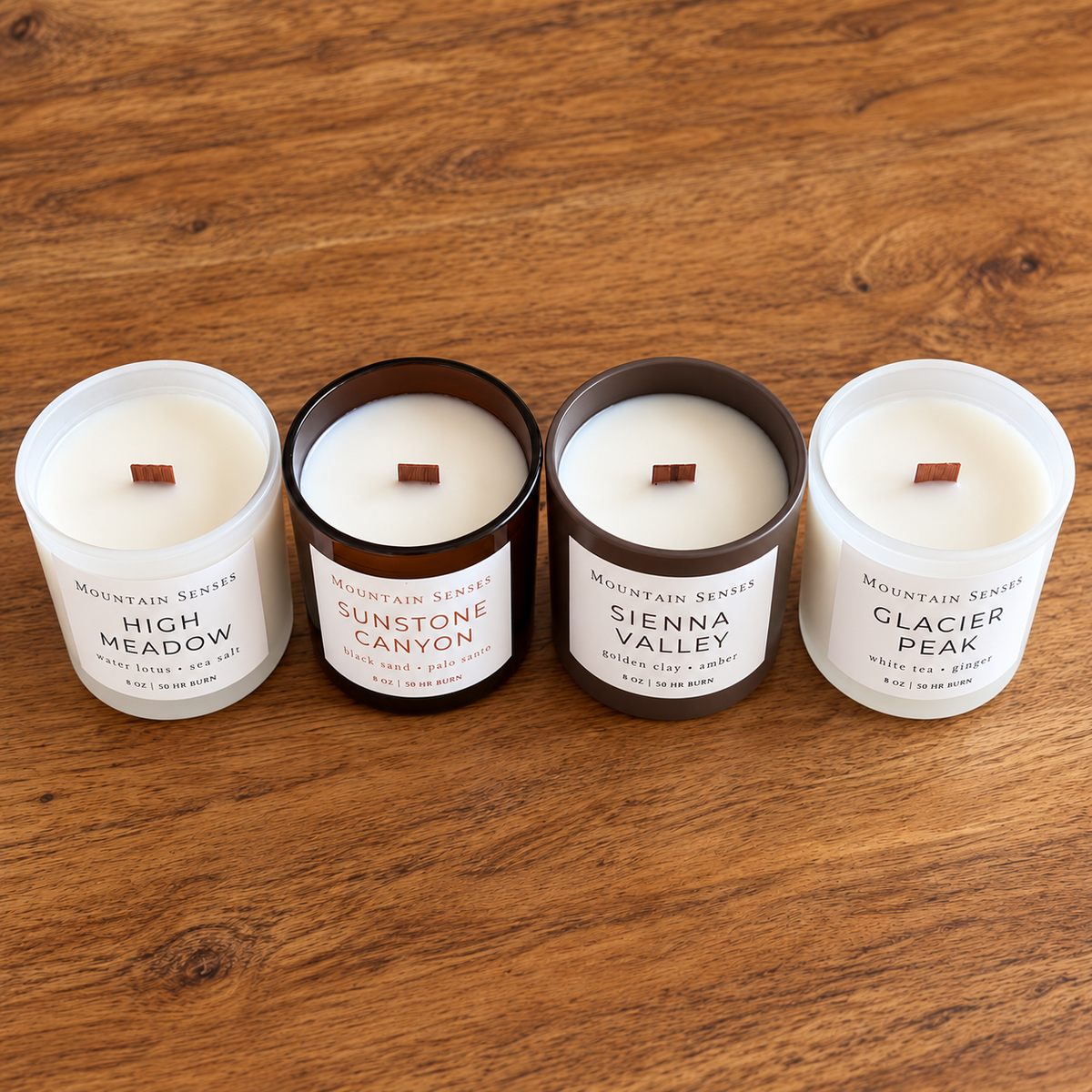 Four Seasons candle collection from above showing all four fragrances and their wooden wicks on a warm wooden table