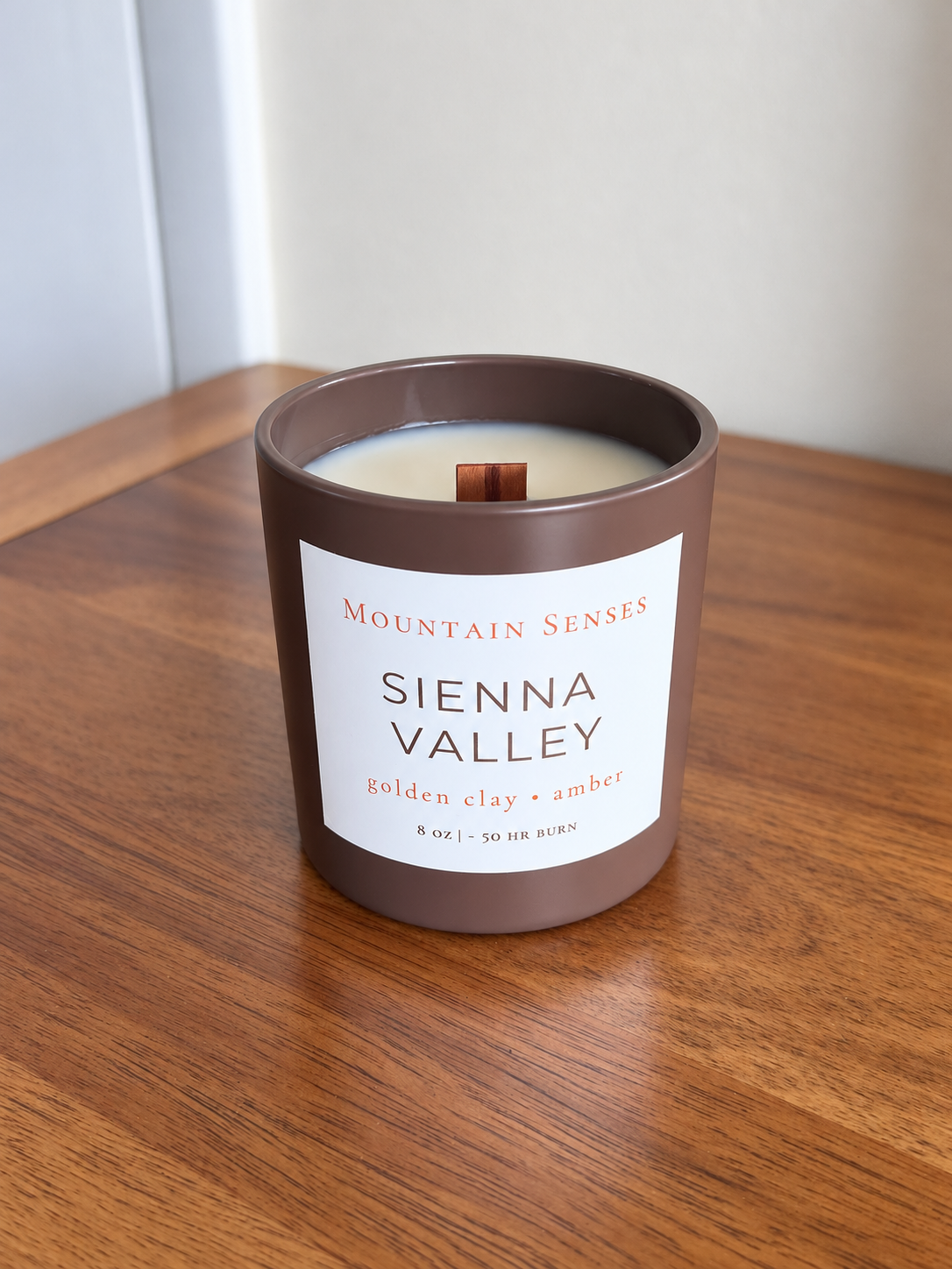 Sienna Valley 8 oz Ritual Refill candle with unlit wooden wick on a wooden table