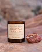 Sunstone Canyon candle and natural red-banded stone photographed in Goblin Valley, Utah
